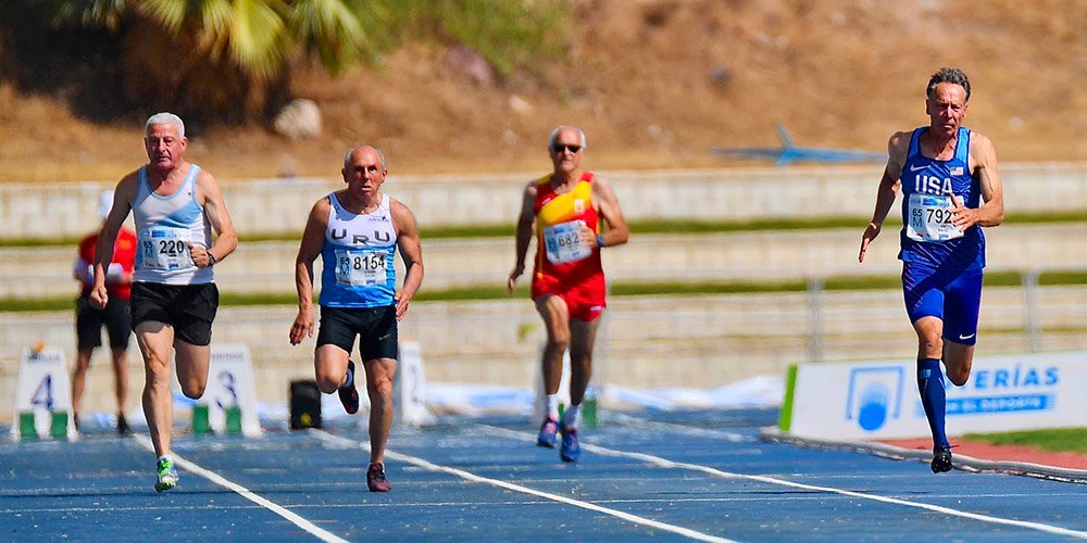 Michael Kish (right) leads Malaga heat in the M65 100. He won silver in final but wasn't on the 4x100 relay.