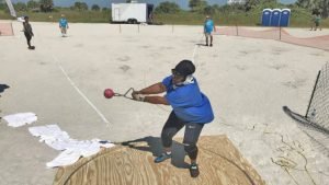 Wearing a neck brace after her most recent accident, Neni Lewis throws the weight at Sunshine State Games.