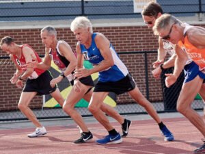 Dan, in blue, starts a track race in running flats.