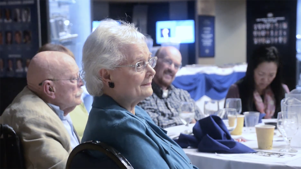 Linda Pain listens to plaudits for husband David at San Diego TC event.