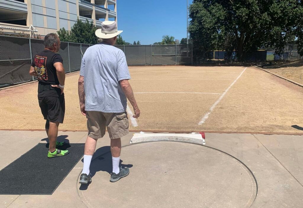 USATF field referee checks out shot put ring at American River College.