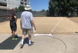 USATF field referee checks out shot put ring at American River College.